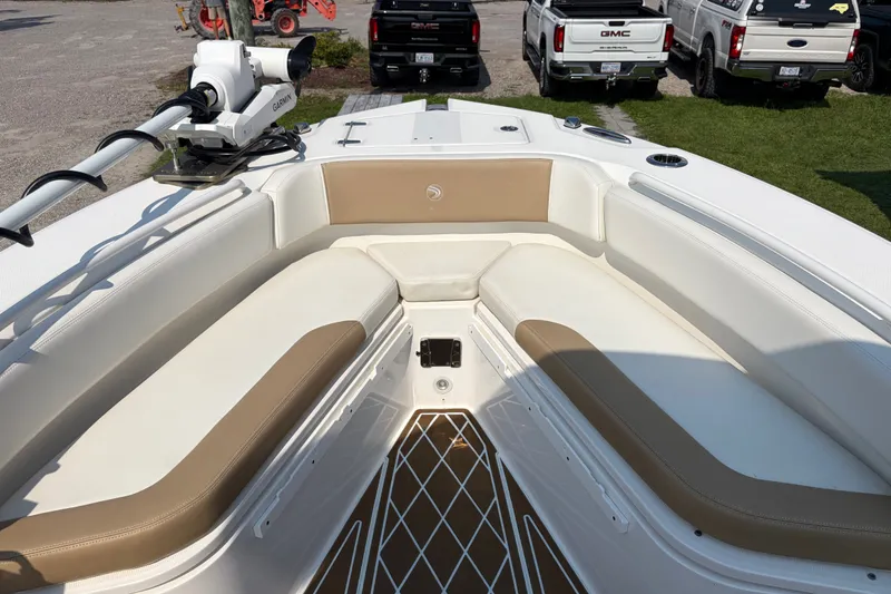 Slide: The Image of Edgewater 230CC 2022 boat interior with cushioned seating and Garmin equipment. - 9