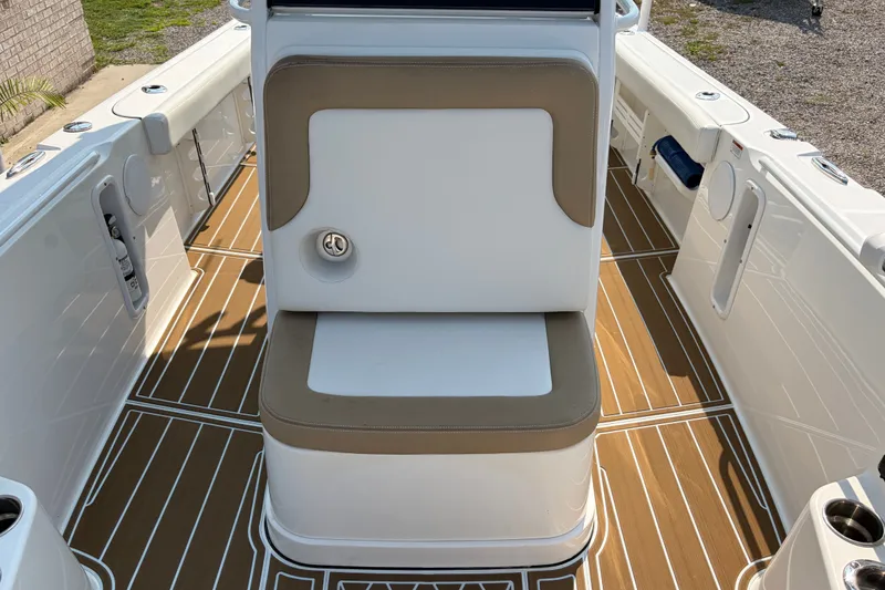 Slide: The Image of 2022 Edgewater 230CC boat interior with cushioned seating and teak-style flooring. - 13