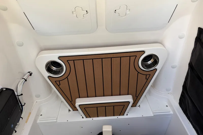 Slide: The Image of Interior of 2022 Edgewater 230CC boat featuring a wooden panel and storage compartments. - 15