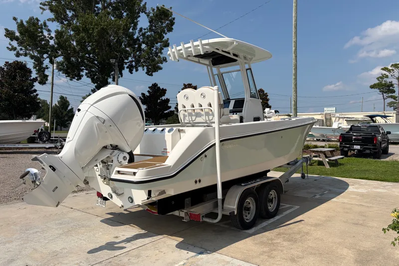 Slide: The Image of 2022 Edgewater 230CC boat on trailer, featuring a powerful outboard motor, parked outdoors. - 4
