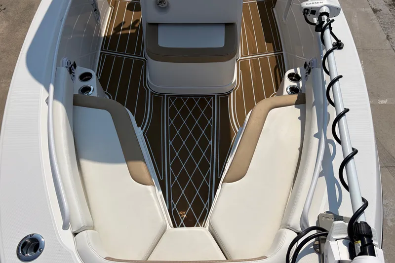 Slide: The Image of 2022 Edgewater 230CC boat interior with cushioned seating and teak-style flooring. - 11