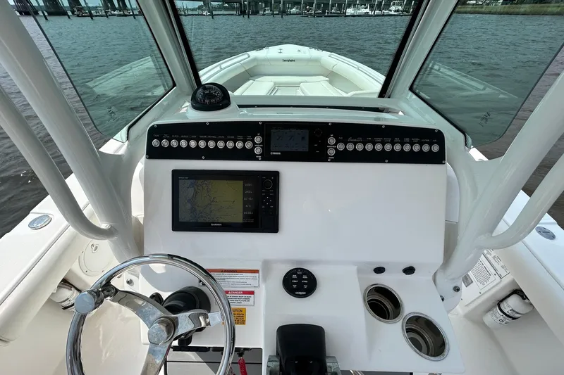 Slide: The Image of 2018 Everglades 273 Center Console boat dashboard with navigation equipment and steering wheel. - 1