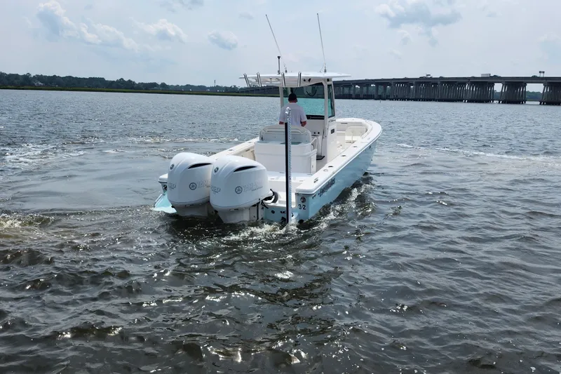 Slide: The Image of 2018 Everglades 273 Center Console boat cruising on a calm river near a bridge. - 17