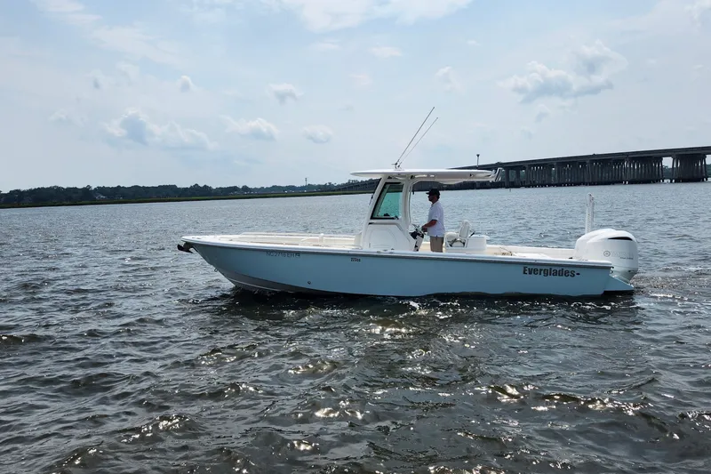 Slide: The Image of 2018 Everglades 273 Center Console boat cruising on a sunny day near a bridge. - 8