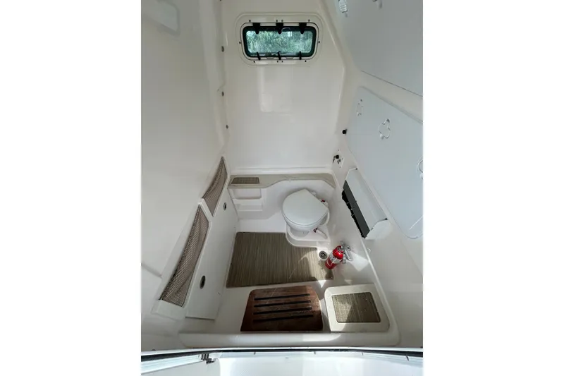 Slide: The Image of Interior of 2018 Everglades 273 Center Console boat, featuring a compact marine toilet. - 7