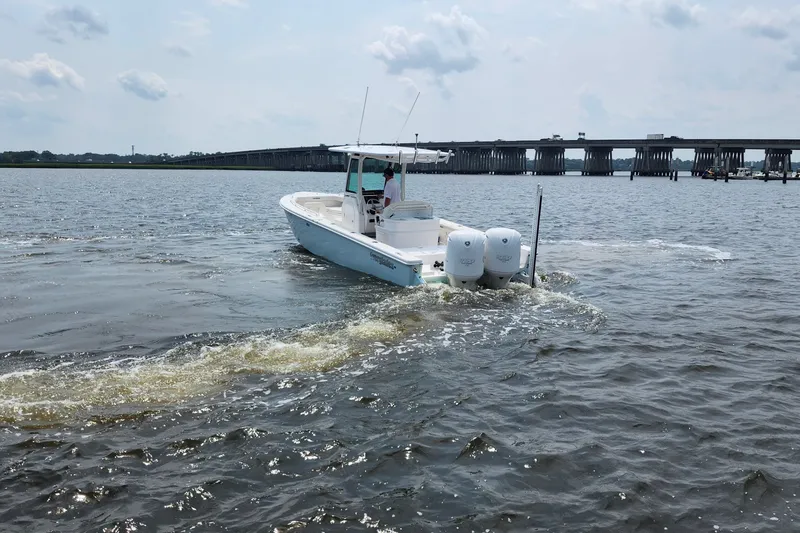 Slide: The Image of 2018 Everglades 273 Center Console boat cruising on a river near a bridge. - 18