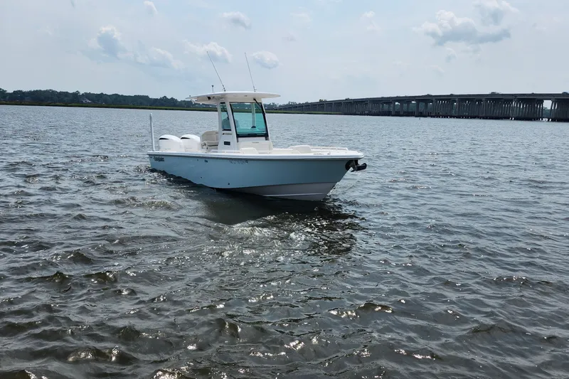 Slide: The Image of 2018 Everglades 273 Center Console boat on calm water near a bridge. - 11
