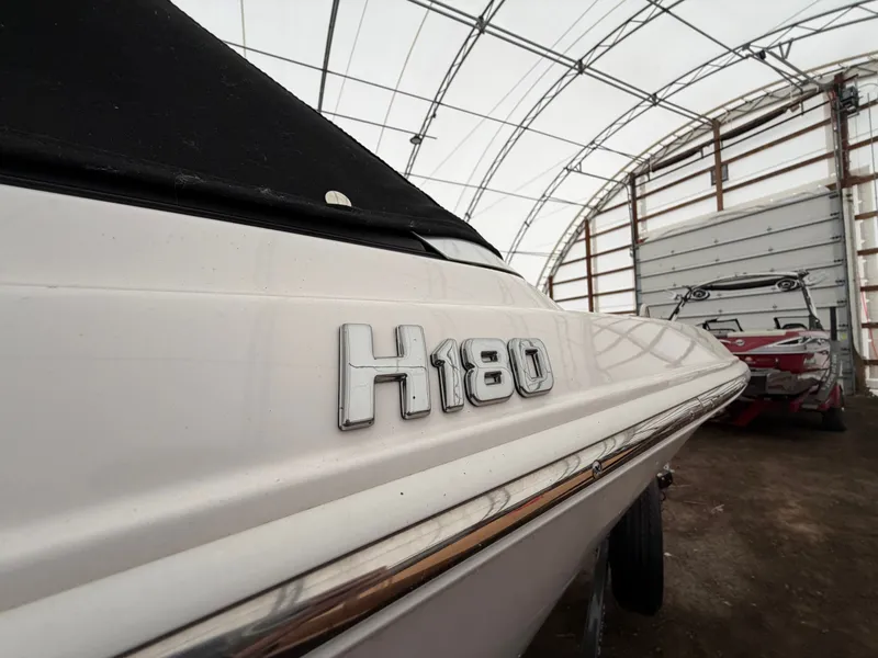 Slide: The Image of Close-up of the 2017 Four Winns H180 SS in a covered area. - 9