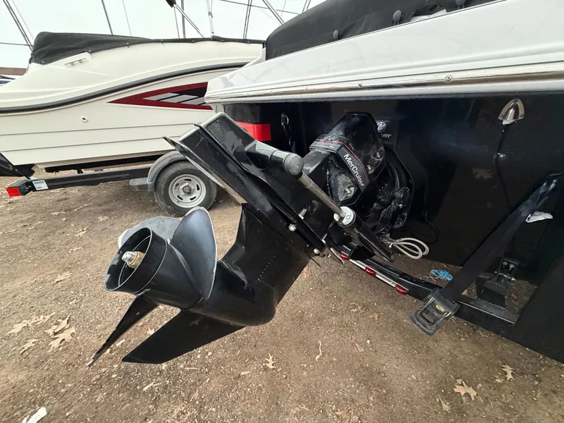 Slide: The Image of An outboard motor of a 2017 Four Winns H180 SS boat, parked on a trailer. - 6