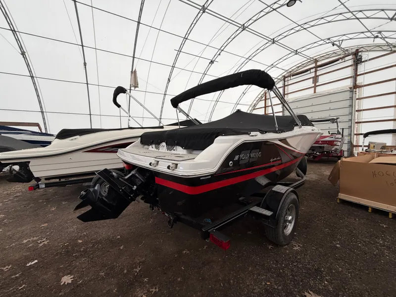 Slide: The Image of A 2017 Four Winns H180 SS boat is on a trailer in a covered storage area. - 3