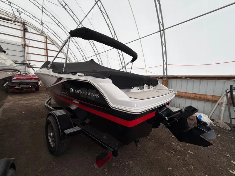 Slide: The Image of A 2017 Four Winns H180 SS boat on a trailer in a covered area. - 4