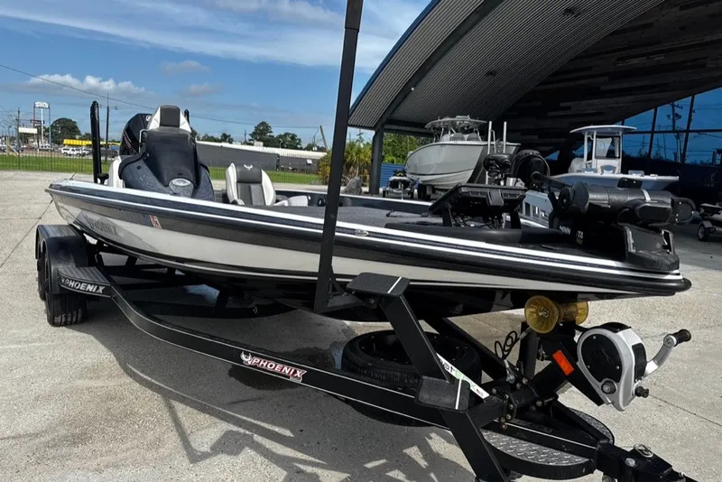 Slide: The Image of 2023 Phoenix 721 ProXP boat on trailer, parked outdoors near a modern building. - 6