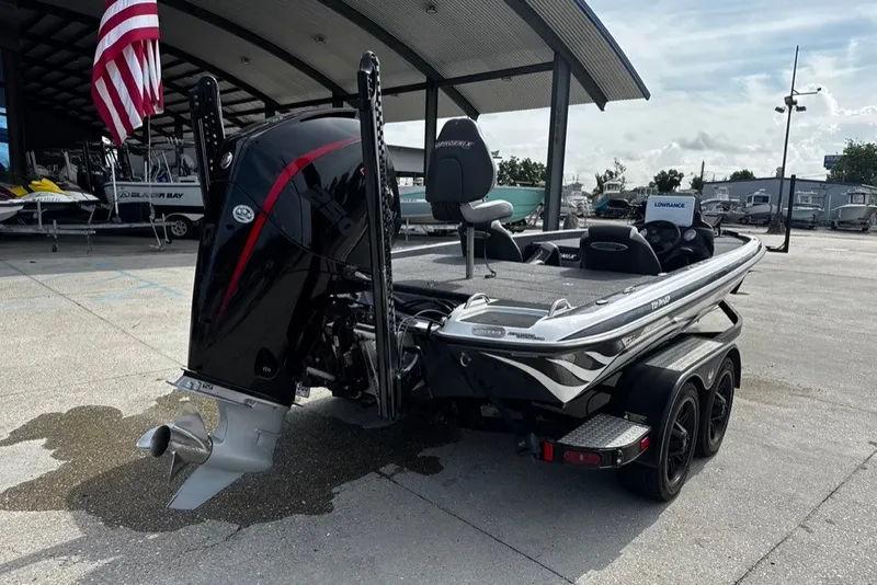 Slide: The Image of 2023 Phoenix 721 ProXP boat with powerful outboard motor, parked under a canopy. - 9
