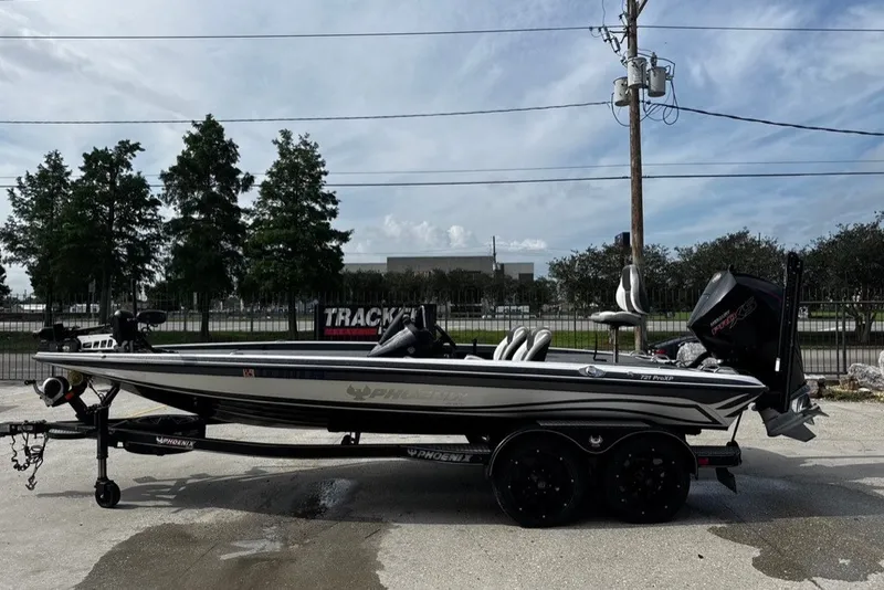 Slide: The Image of 2023 Phoenix 721 ProXP boat on trailer, parked outdoors under a cloudy sky. - 5