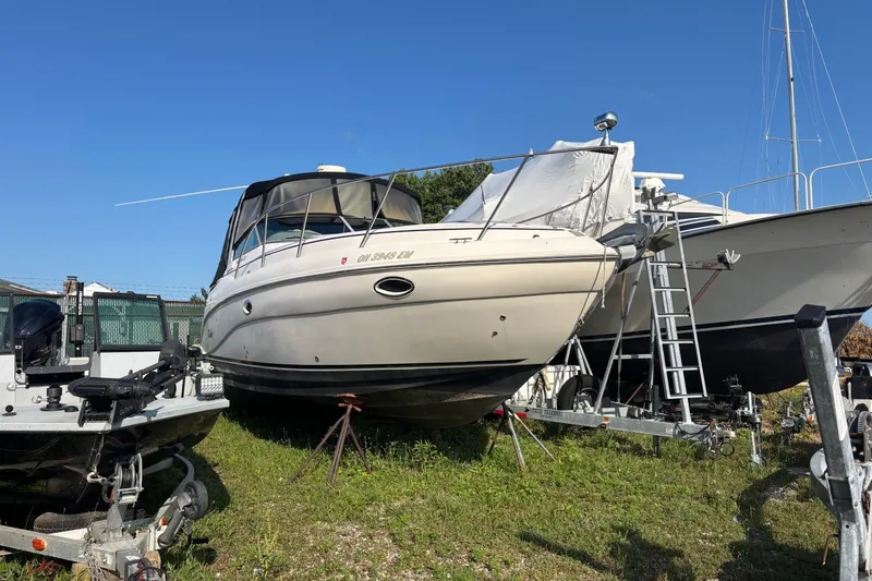Slide: The Image of 2003 Rinker Fiesta Vee 312 boat on trailer, parked outdoors under clear blue sky. - 1
