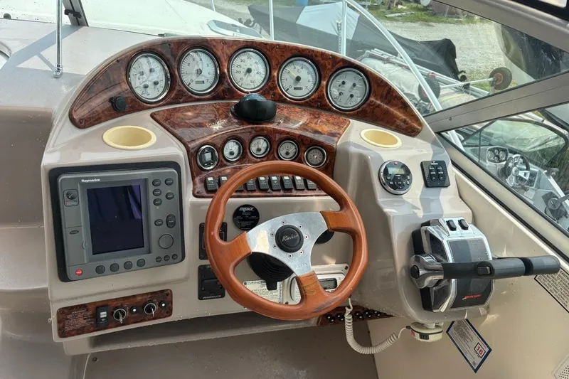 Slide: The Image of 2003 Rinker Fiesta Vee 312 boat dashboard with gauges, steering wheel, and navigation system. - 16