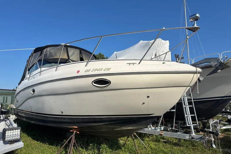 Slide: The Image of 2003 Rinker Fiesta Vee 312 boat on stands, with clear blue sky background. - 2