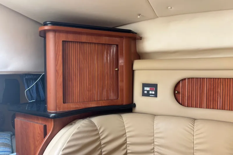 Slide: The Image of Interior of 2003 Rinker Fiesta Vee 312 with wood cabinetry and beige seating. - 29