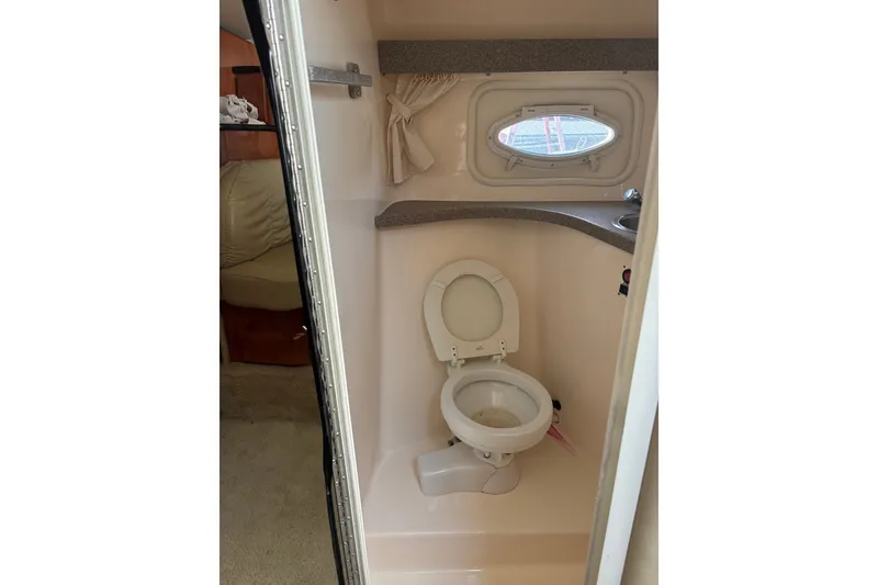 Slide: The Image of 2003 Rinker Fiesta Vee 312 boat bathroom with toilet and porthole window. - 24
