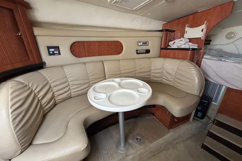 Slide: The Image of 2003 Rinker Fiesta Vee 312 cabin interior with beige leather seating and round table. - 30
