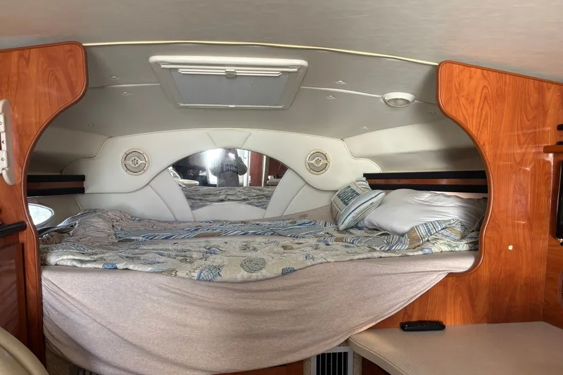 Slide: The Image of Cozy cabin interior of 2003 Rinker Fiesta Vee 312 boat with bed and wood accents. - 26