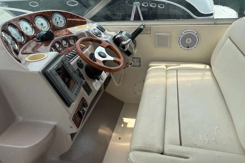 Slide: The Image of 2003 Rinker Fiesta Vee 312 boat cockpit with steering wheel and control panel. - 14