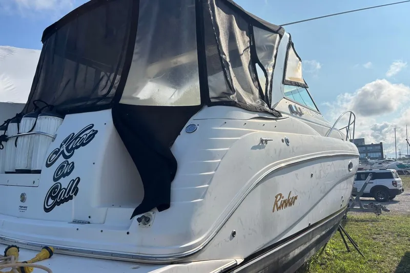 Slide: The Image of 2003 Rinker Fiesta Vee 312 boat docked, featuring a covered cabin and sleek design. - 5