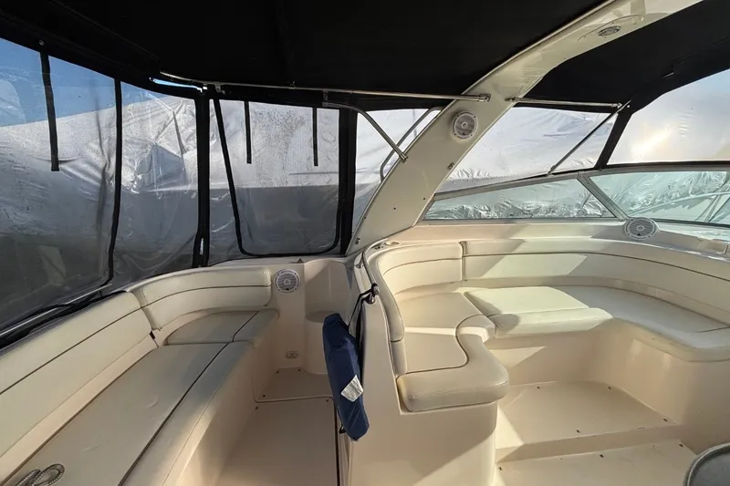 Slide: The Image of 2003 Rinker Fiesta Vee 312 boat interior with beige seating and black canopy. - 12