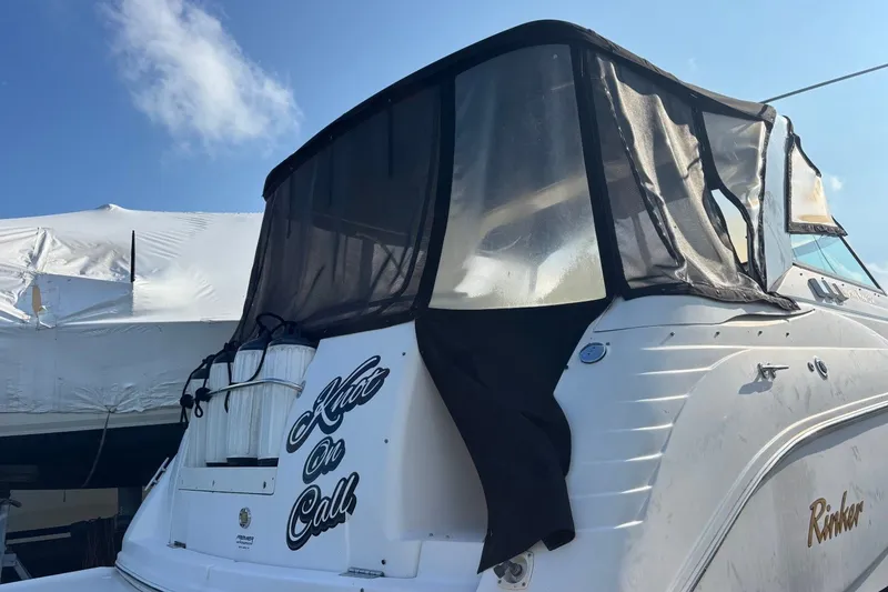 Slide: The Image of 2003 Rinker Fiesta Vee 312 boat with black canopy and "Knot On Call" text. - 4