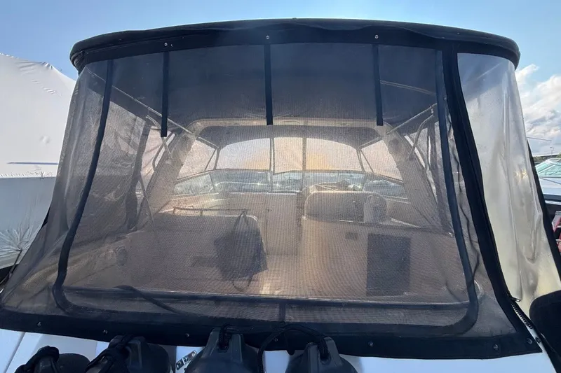 Slide: The Image of 2003 Rinker Fiesta Vee 312 boat with covered cockpit and clear enclosure. - 7