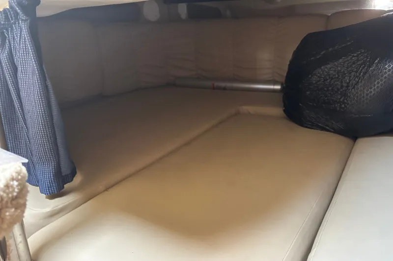 Slide: The Image of Interior cabin of 2003 Rinker Fiesta Vee 312 with beige seating and blue curtains. - 27