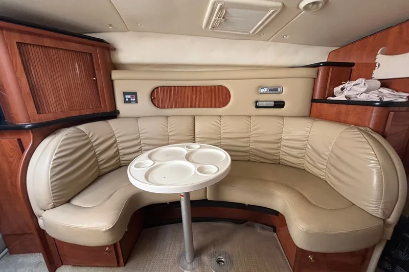 Slide: The Image of 2003 Rinker Fiesta Vee 312 cabin interior with beige leather seating and wooden cabinetry. - 25