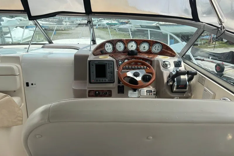 Slide: The Image of 2003 Rinker Fiesta Vee 312 boat dashboard with gauges, steering wheel, and navigation controls. - 18