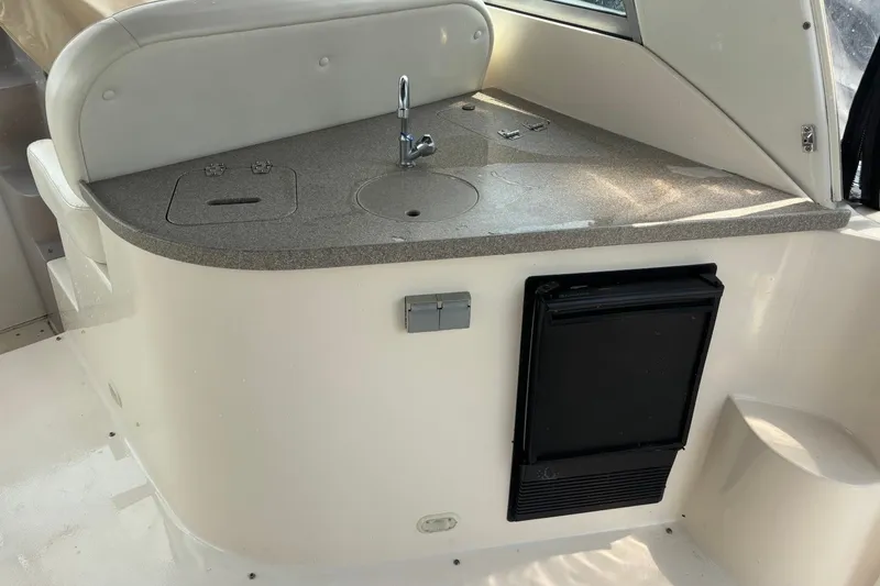 Slide: The Image of 2003 Rinker Fiesta Vee 312 boat interior with kitchenette and mini fridge. - 13