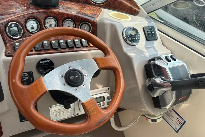 Slide: The Image of 2003 Rinker Fiesta Vee 312 boat dashboard with wooden steering wheel and control panel. - 17