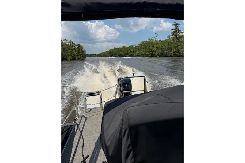 Slide: The Image of 2024 Barletta A22UC boat cruising on a river, leaving a wake behind. - 15