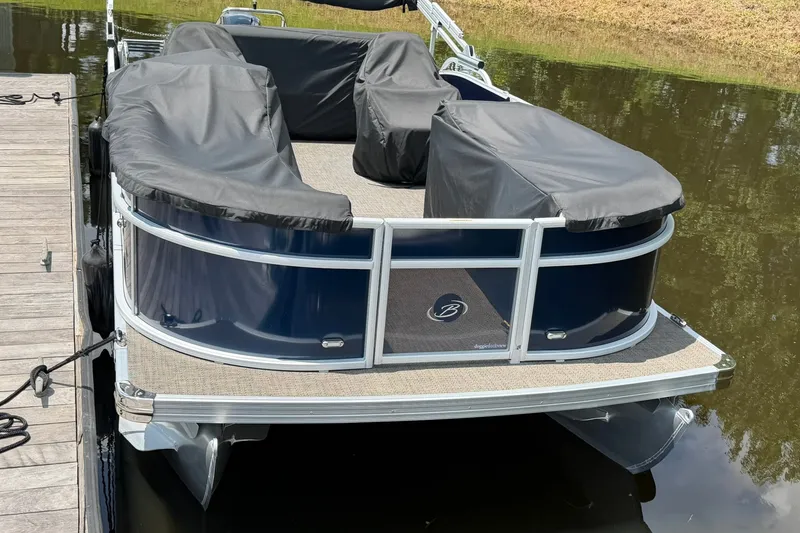 Slide: The Image of 2024 Barletta A22UC pontoon boat docked, covered seats, sleek design. - 3