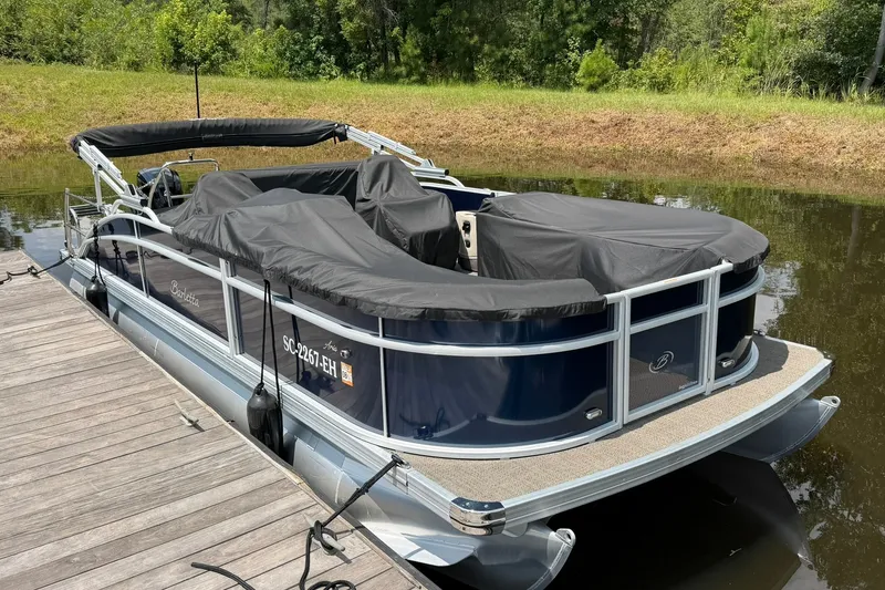 Slide: The Image of 2024 Barletta A22UC pontoon boat docked with protective covers on. - 1