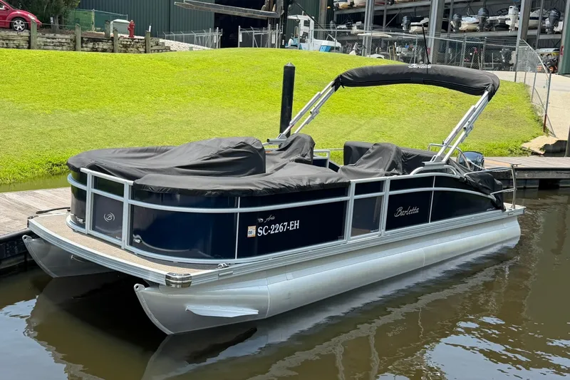 Slide: The Image of 2024 Barletta A22UC pontoon boat docked, covered, with sleek design and modern features. - 5