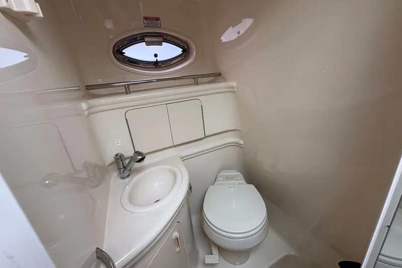 Slide: The Image of 2004 Sea Ray Sundancer 280 bathroom with sink, toilet, and porthole window. - 19