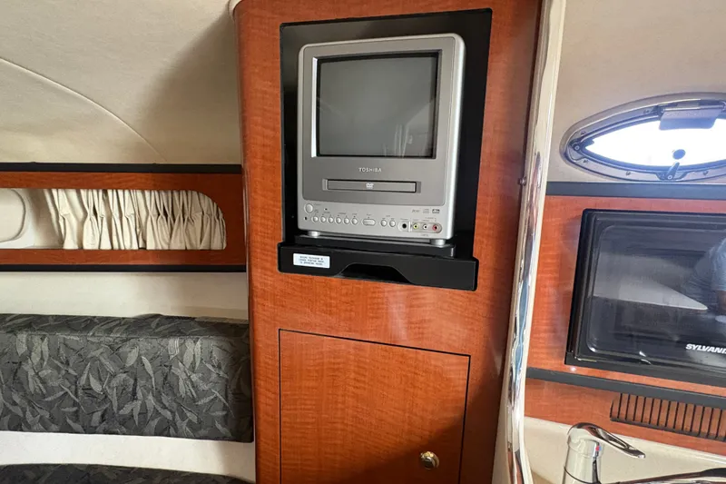 Slide: The Image of 2004 Sea Ray Sundancer 280 interior with TV and wood paneling. - 14