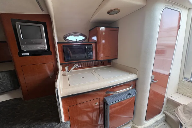 Slide: The Image of Interior of 2004 Sea Ray Sundancer 280 with kitchenette, TV, and microwave. - 13