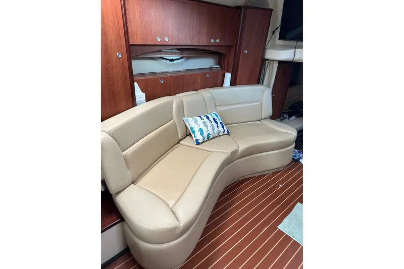 Slide: The Image of Luxurious interior of 2008 Monterey 330 Sport Yacht with curved beige seating and wooden cabinetry. - 25