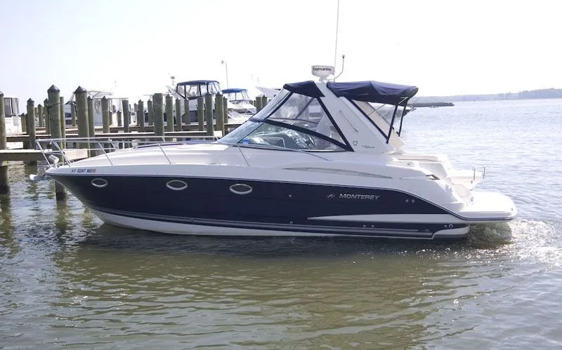 The Image of 2008 Monterey 330 Sport Yacht docked, featuring a blue hull and white canopy. - 0