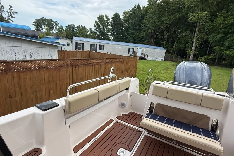 Slide: The Image of 2025 Ranger Tugs R-25 boat deck with seating, wooden flooring, and outdoor view. - 9
