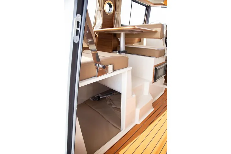 Slide: The Image of Manufacturer Provided Image: Interior of 2025 Ranger Tugs R-25 boat with wooden flooring and seating area. - 14