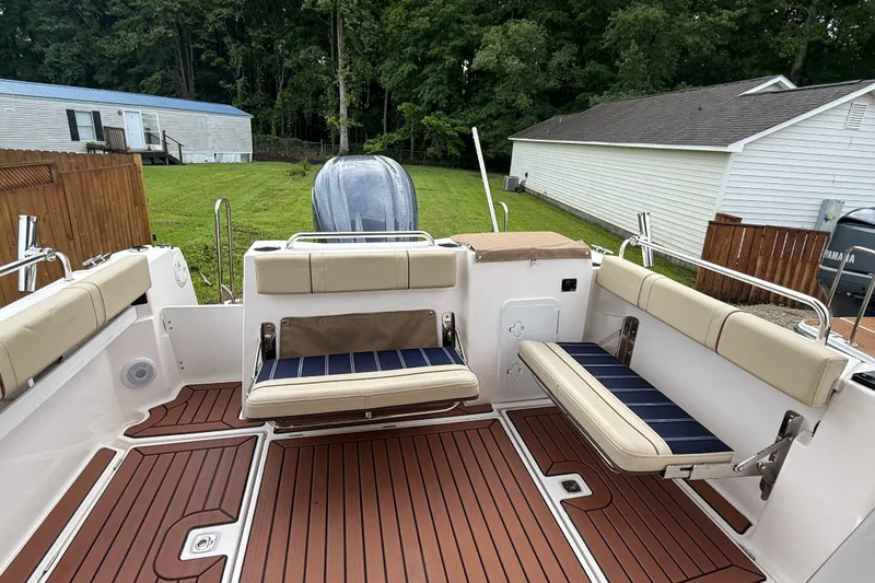 Slide: The Image of 2025 Ranger Tugs R-25 boat interior with cushioned seating and wood-style flooring. - 8