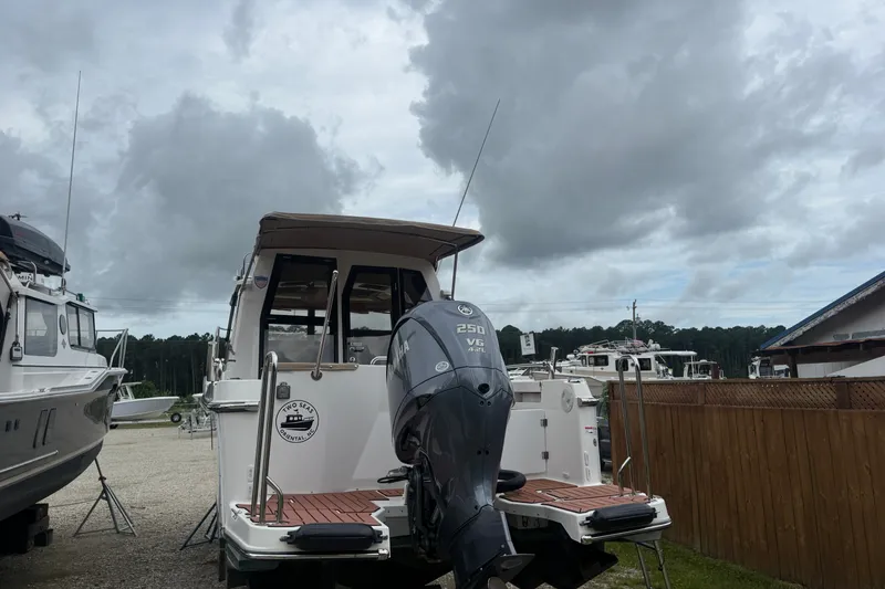Slide: The Image of 2025 Ranger Tugs R-25 boat with Yamaha 250 V6 engine, docked under cloudy skies. - 4