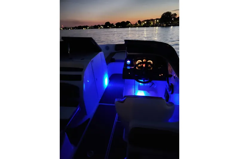 Slide: The Image of 2019 Bayliner VR6 Bowrider I/O interior with blue ambient lighting at sunset. - 26