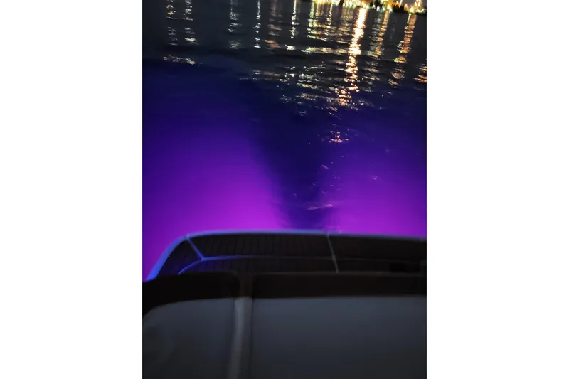 Slide: The Image of 2019 Bayliner VR6 Bowrider I/O with purple underwater lights at night. - 22